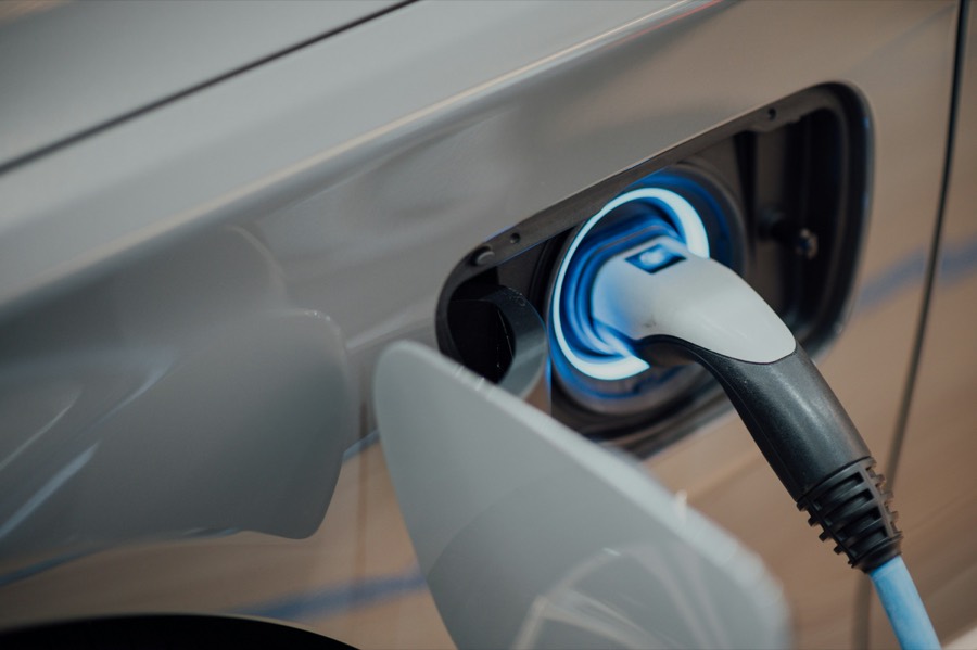 Charging plug connected to electric car with blue LED ring